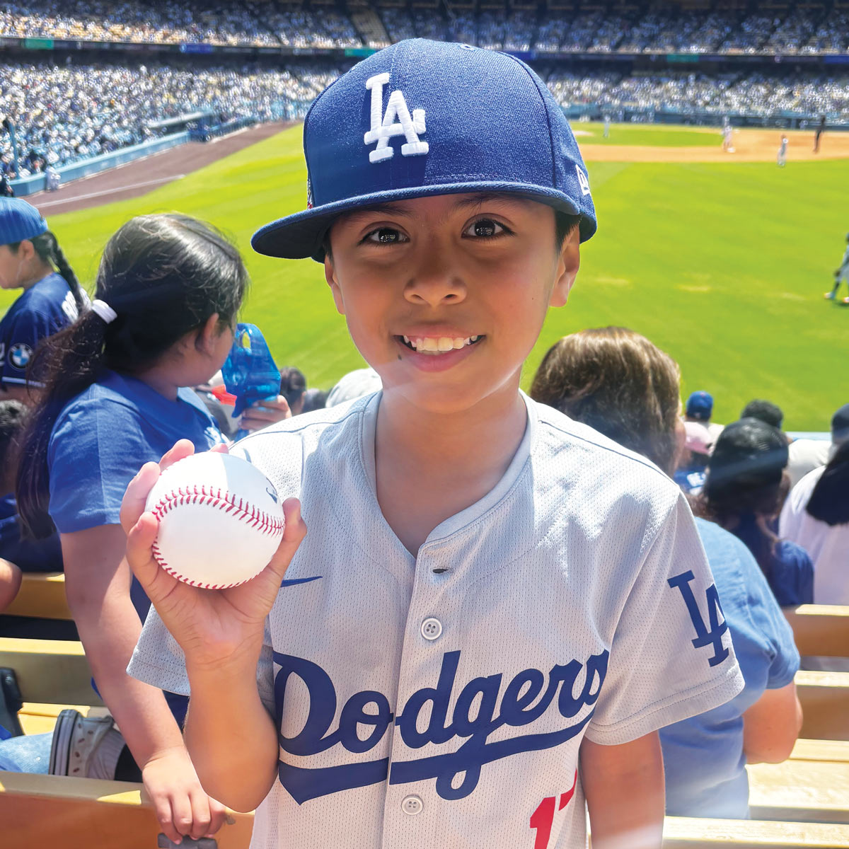 Young Dodgers fan holding a ball